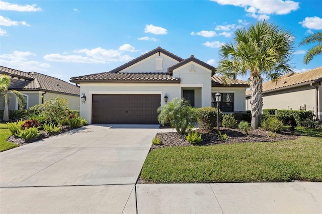 view of front of home with stucco siding, a front yard, a garage, driveway, and a tiled roof