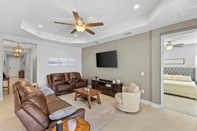 living room with visible vents, a tray ceiling, baseboards, and recessed lighting