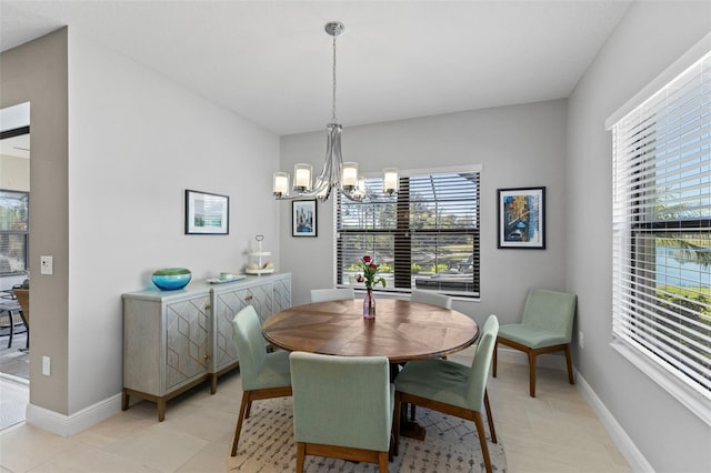 dining space with light tile patterned floors, baseboards, and an inviting chandelier