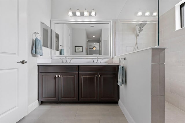 full bath with double vanity, walk in shower, a sink, and tile patterned floors