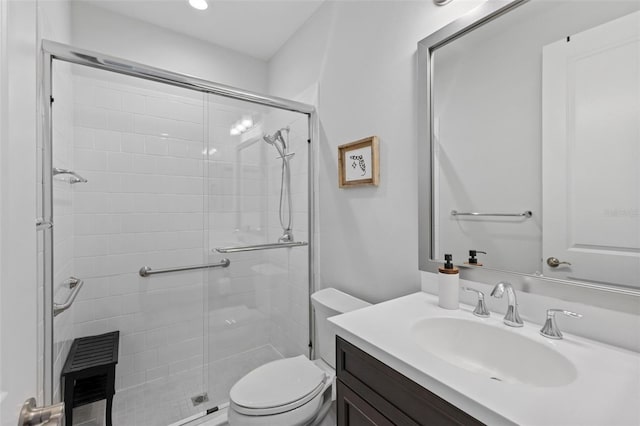 bathroom with toilet, a stall shower, and vanity