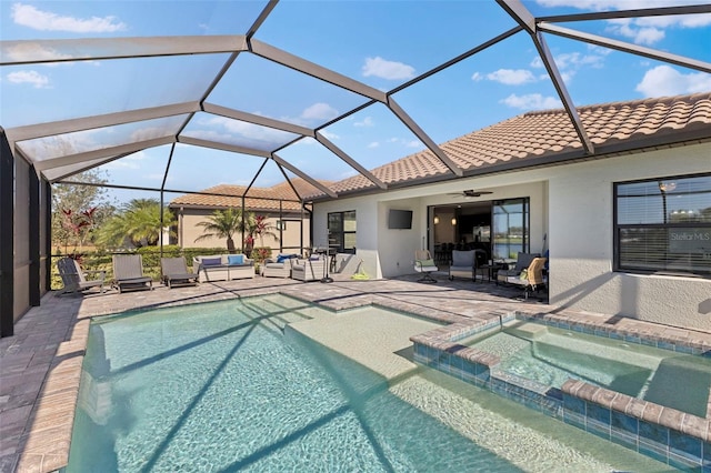 view of pool featuring a pool with connected hot tub, a patio, an outdoor living space, and a lanai