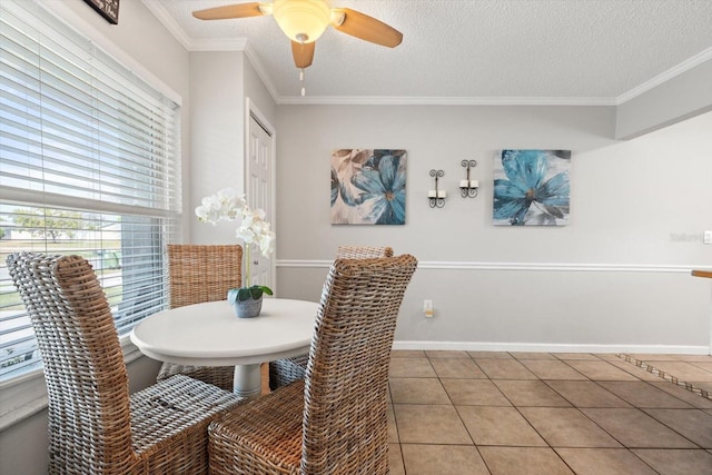 dining space with crown molding, a textured ceiling, baseboards, and light tile patterned floors