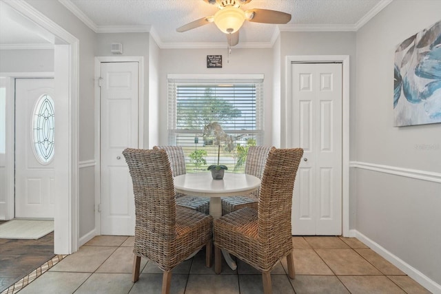 dining room featuring light tile patterned floors, a textured ceiling, a ceiling fan, and crown molding