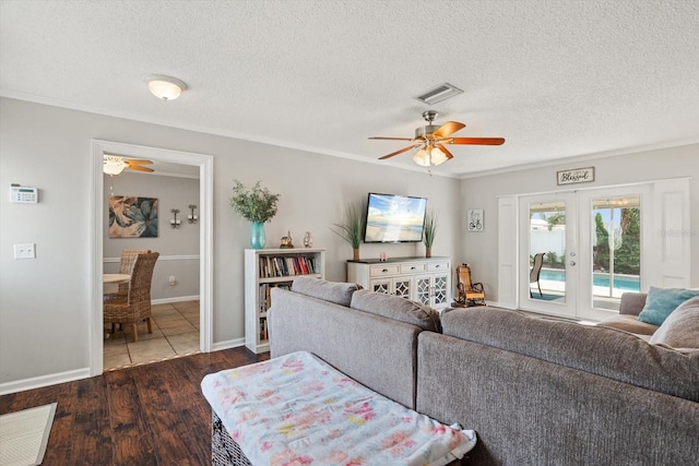 living room featuring visible vents, a ceiling fan, dark wood-type flooring, a textured ceiling, and french doors