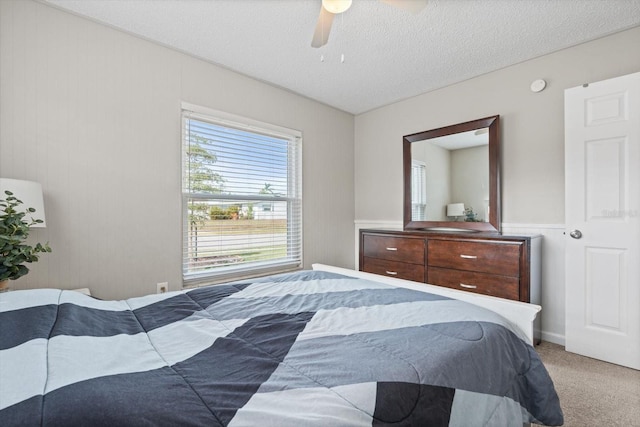 bedroom with carpet flooring, ceiling fan, and a textured ceiling