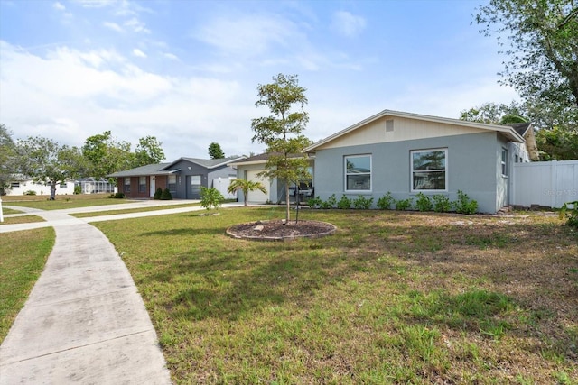 ranch-style home featuring a front yard, concrete driveway, fence, and an attached garage