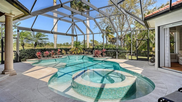 view of pool with a patio area, a lanai, and a pool with connected hot tub