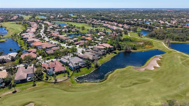 drone / aerial view with a residential view, a water view, and golf course view