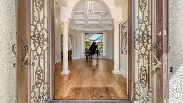 entryway featuring coffered ceiling, decorative columns, baseboards, and wood finished floors