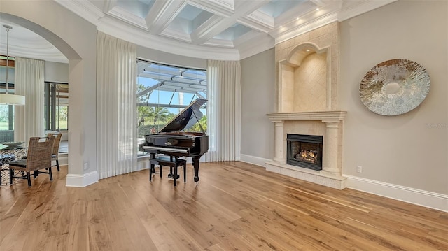 living area featuring beam ceiling, a high end fireplace, wood finished floors, coffered ceiling, and baseboards