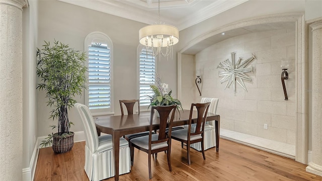 dining room with a chandelier, a wealth of natural light, crown molding, and light wood-style flooring