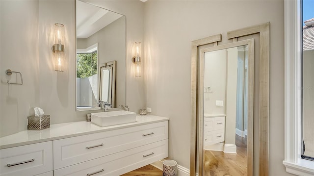 bathroom featuring wood finished floors, vanity, and baseboards