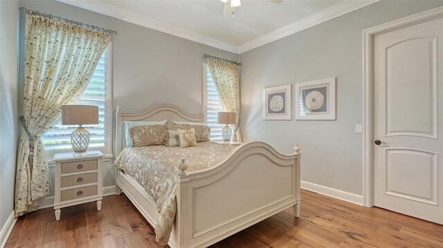 bedroom featuring baseboards, crown molding, and wood finished floors