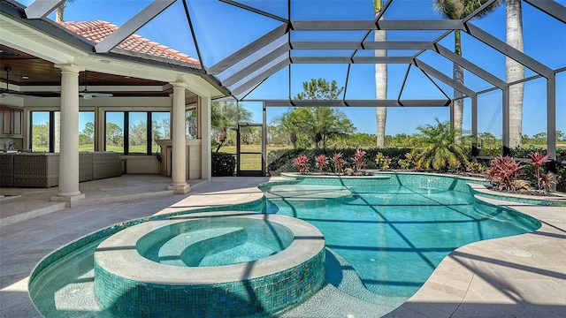 view of pool featuring glass enclosure, an outdoor hangout area, a pool with connected hot tub, a ceiling fan, and a patio area