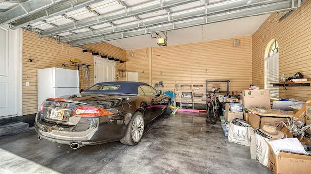 garage with freestanding refrigerator and a garage door opener