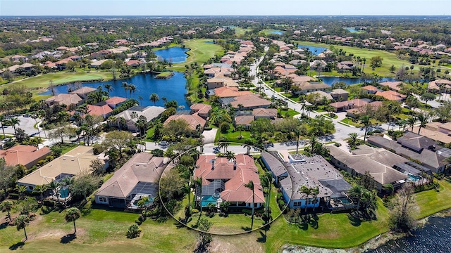 birds eye view of property with view of golf course, a water view, and a residential view