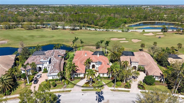 aerial view with a water view, a view of trees, and golf course view