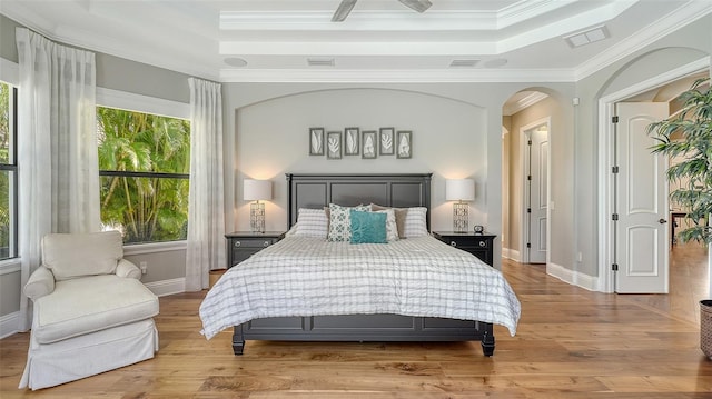 bedroom featuring crown molding, a tray ceiling, and wood finished floors