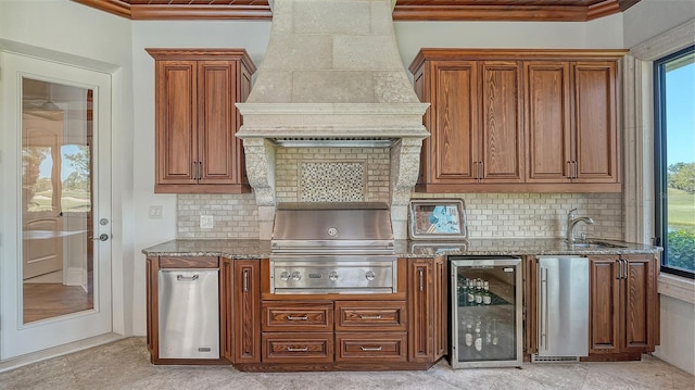 kitchen with stone countertops, beverage cooler, stainless steel fridge, refrigerator, and premium range hood