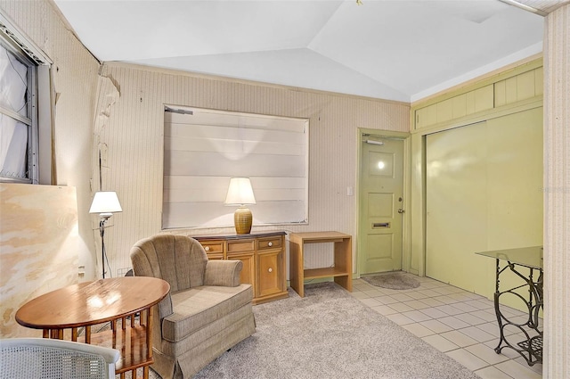 living area featuring light tile patterned flooring, vaulted ceiling, and light carpet