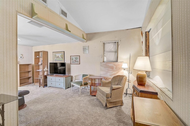 carpeted living room with visible vents and vaulted ceiling