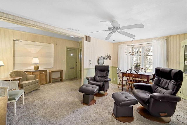 living area featuring light carpet, wallpapered walls, and ceiling fan with notable chandelier