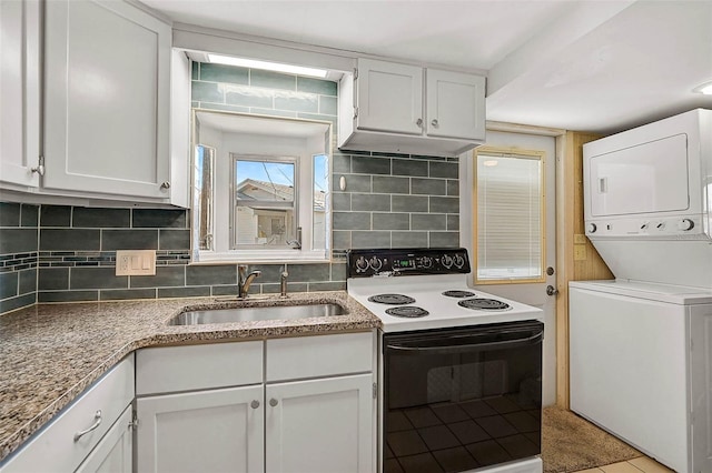 kitchen featuring tasteful backsplash, electric range oven, stacked washer / drying machine, under cabinet range hood, and a sink