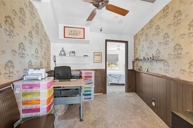 carpeted office with lofted ceiling, wainscoting, ceiling fan, and wallpapered walls