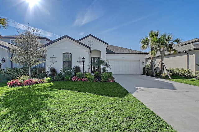 view of front of house featuring a garage, driveway, a front lawn, and stucco siding