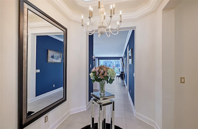 hall featuring an inviting chandelier, baseboards, light tile patterned floors, and ornamental molding