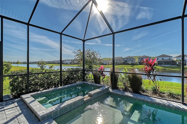 view of swimming pool with glass enclosure, a water view, a residential view, and a pool with connected hot tub