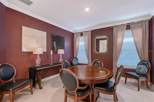 dining area featuring baseboards, light tile patterned flooring, visible vents, and crown molding