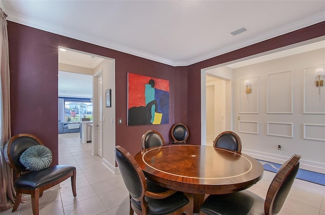 dining area with light tile patterned floors, crown molding, visible vents, and baseboards