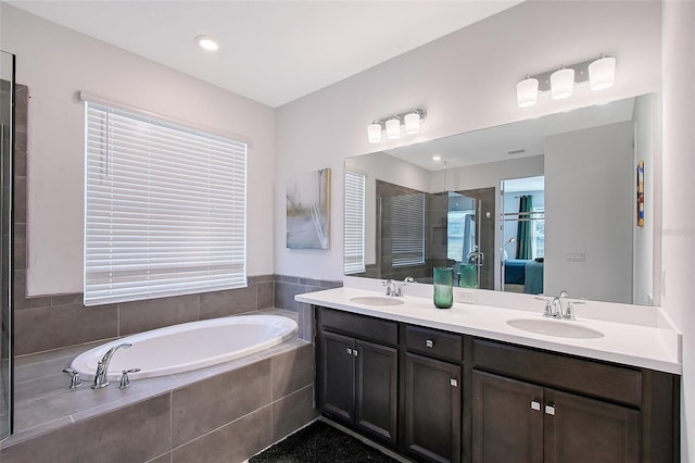 bathroom with double vanity, a stall shower, a sink, and a bath