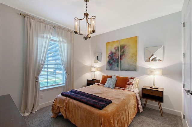 carpeted bedroom featuring baseboards and a notable chandelier