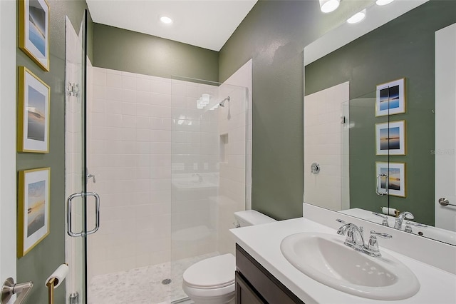 bathroom featuring a stall shower, vanity, and toilet