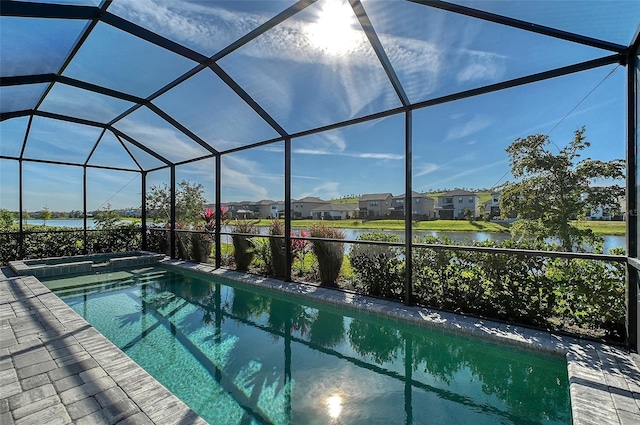 view of pool with a patio, glass enclosure, a residential view, a water view, and a pool with connected hot tub