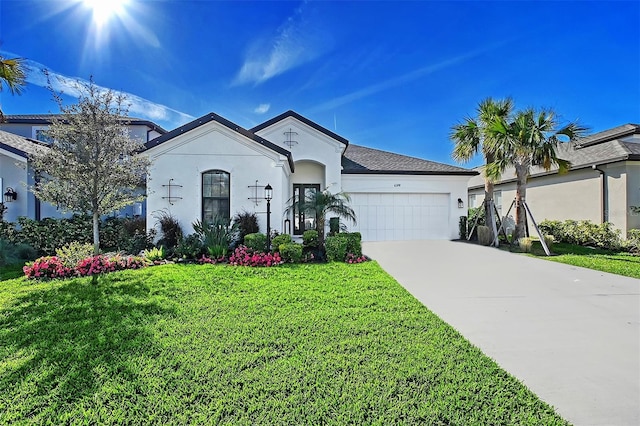 view of front of house with a front yard, an attached garage, driveway, and stucco siding