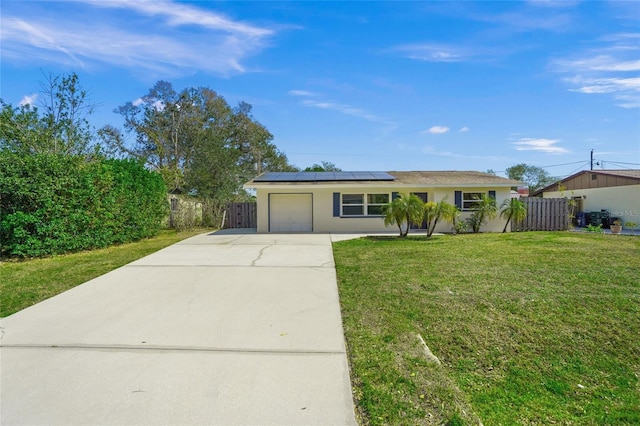 single story home with a garage, concrete driveway, roof mounted solar panels, stucco siding, and a front yard