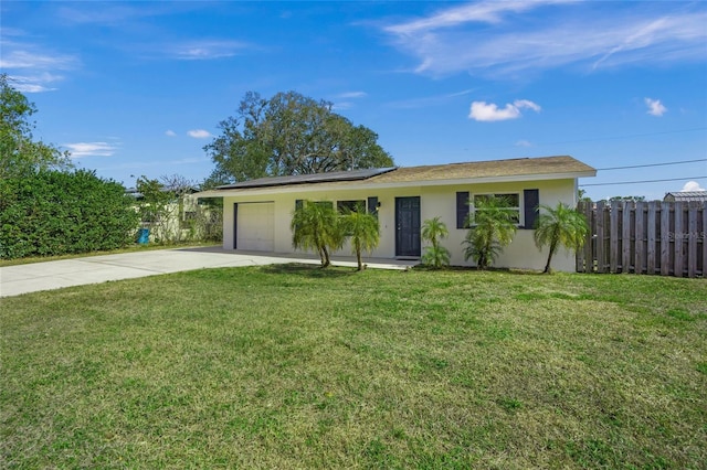 ranch-style house featuring a garage, solar panels, fence, concrete driveway, and stucco siding