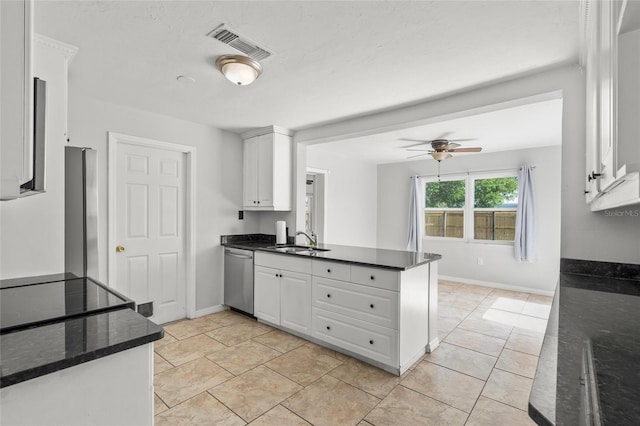 kitchen with stainless steel appliances, white cabinets, a sink, and a peninsula