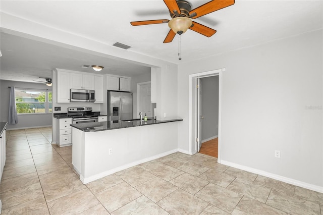 kitchen with a peninsula, a sink, visible vents, white cabinets, and appliances with stainless steel finishes