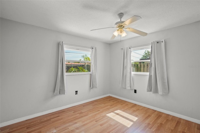 unfurnished room featuring a healthy amount of sunlight, light wood-style flooring, and baseboards