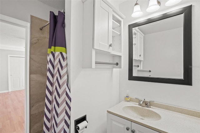 full bath with a shower with curtain, wood finished floors, and vanity