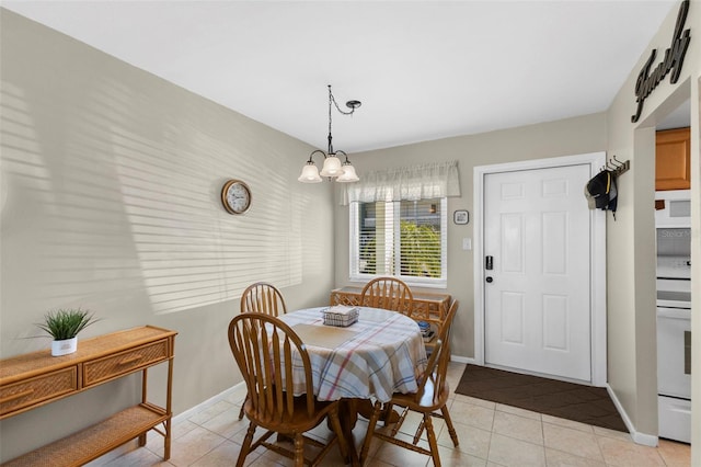 dining area with light tile patterned floors, baseboards, and a notable chandelier