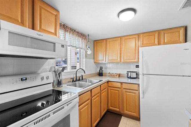 kitchen featuring light countertops, visible vents, light tile patterned flooring, a sink, and white appliances