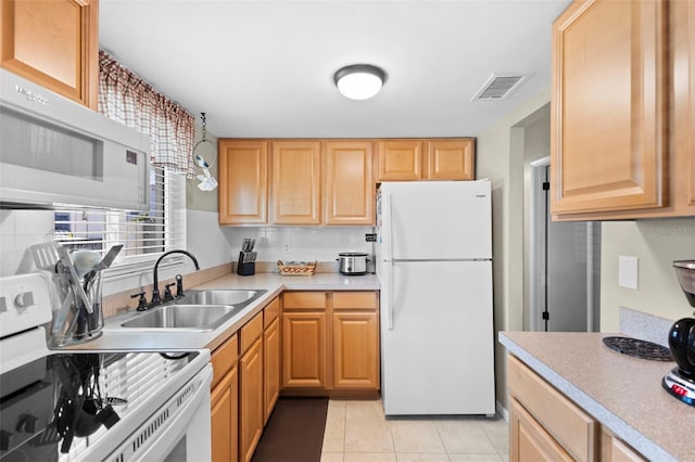 kitchen with light tile patterned floors, light countertops, visible vents, a sink, and white appliances