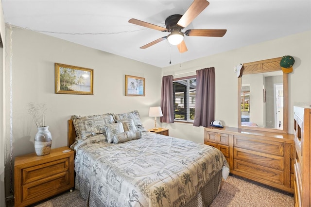 bedroom with a fireplace, a ceiling fan, and light colored carpet