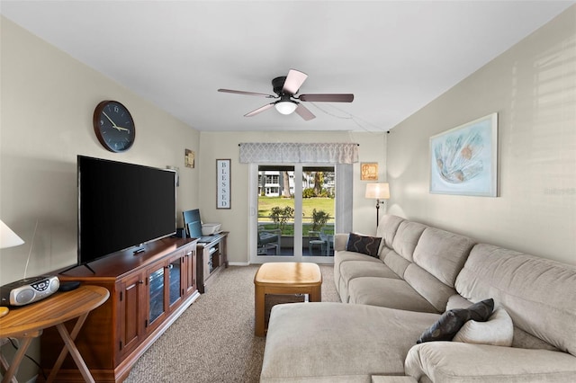 carpeted living area featuring a ceiling fan and baseboards